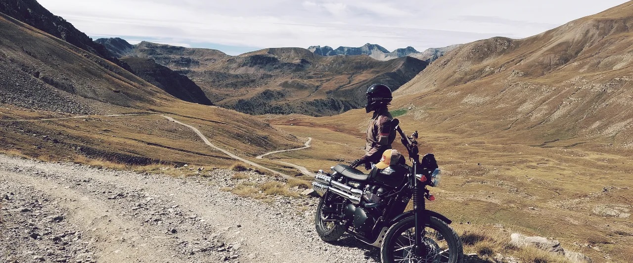 Rider looks back across unsurfaced road